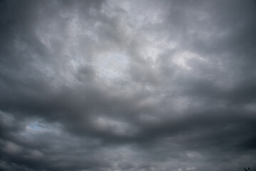 Obraz premium Dark gray sky cloudy environment. Meteorology danger windstorm disasters climate. Dramatic dark storm rain clouds black sky background. Dark cloudscape storm disaster gloomy gray cloud sky. Nimbus