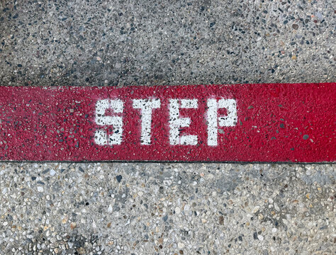 A red concrete curb marked STEP