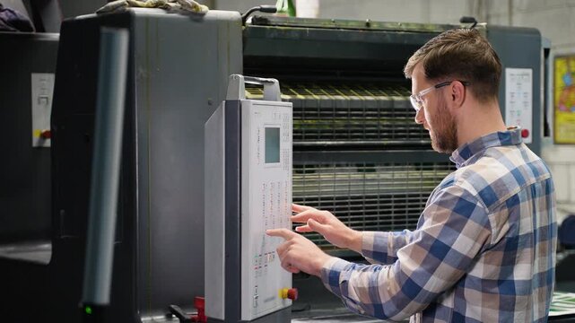 Male printer operating offset printing machine control panel