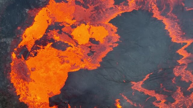 Aerial view of glowing orange lava flowing over dark volcanic rock in the Danakil Desert, Dalol, Afar, Ethiopia.