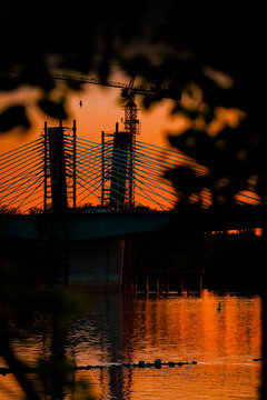 Bridge under construction over the Danube River during a beautiful sunset.