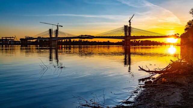 Bridge under construction over the Danube River during a beautiful sunset.
