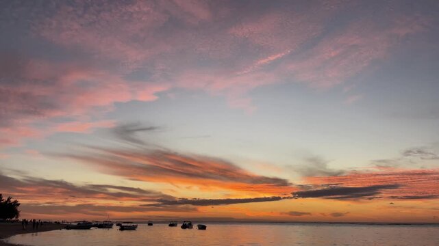 Scenic Tropical Sunset Over Calm Ocean with Boats Anchored at Dusk