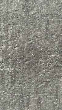 Close-up textured Uniflex waterproofing membrane showing granular gray surface and seams, tight macro framing reveals mineral