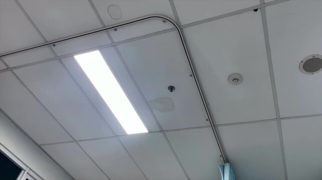 Office ceiling with bright rectangular led panel light and window frame