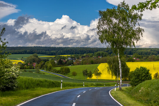 Eine sch&ouml;ne kurvige Landstra&szlig;e mit Blich auf ein Dorf und Wald