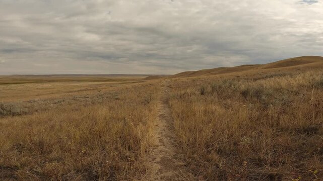 Point of view riding a mountain bike along a rough trail through dry desert terrain
