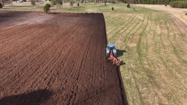 The tractor is preparing the land for the spring sowing. Aerial video.