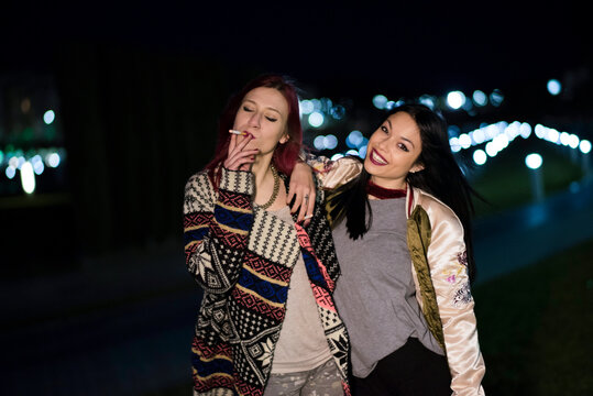 Young Women Friends in Their Twenties Walking Through Night Shopping Street in Jaen Andalusia Spain
