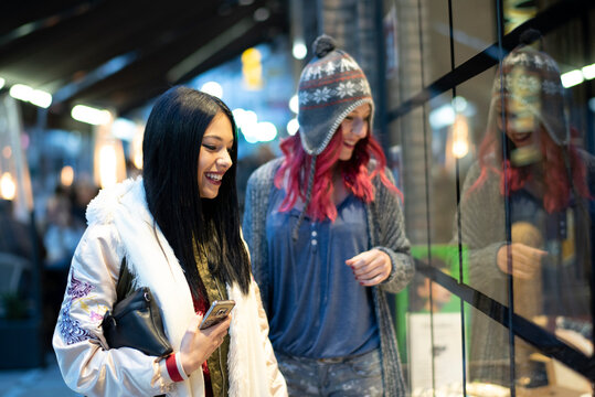 Young Women Friends in Their Twenties Walking Through Night Shopping Street in Jaen Andalusia Spain
