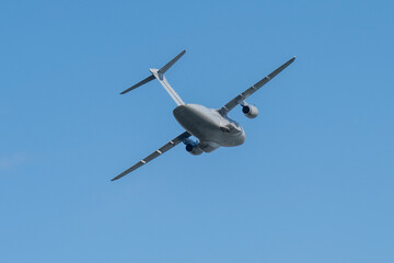 Fototapeta premium Gray hungarian military transport plane flying in the blue sky