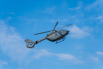 Fototapeta premium Modern military transport helicopter flying in the blue sky in Hungary