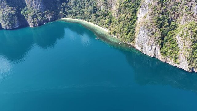 A beautiful beach is fringed by a coral reef on a remote island in El Nido, Philippines. This scenic area of Palawan is a popular vacation destination due to its reefs, beaches, and rock islands.