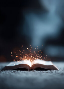 Open book glowing with light and golden sparkles rising from the pages