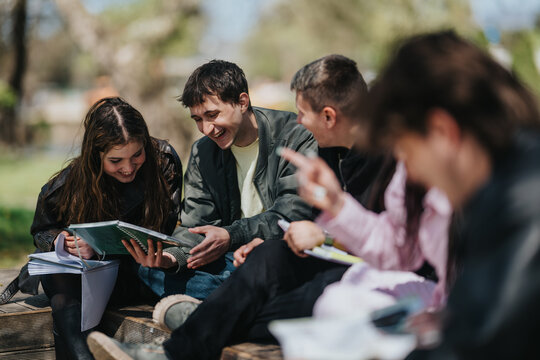 School friends sit on outdoor steps sharing notebooks and smiling as they study together. A group of students collaborate and laugh while reviewing notes in a park-like campus setting.