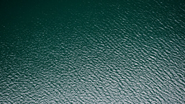 Superficie acu&aacute;tica verde azulada, con ondulaciones suaves y reflejos de luz que evocan calma y movimiento continuo.