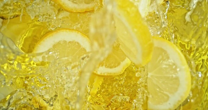Super slow motion 1000fps video of fresh lemon slices falling into rippling water, creating a sparkling splash, perfect for drink, cocktail and summer visuals.