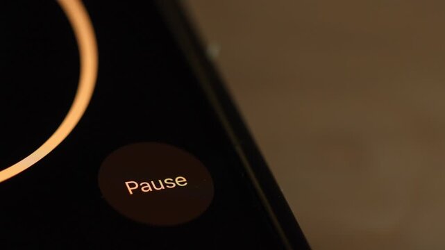 4K close-up footage of a finger tapping between "Resume" and "Pause" buttons on a digital tracking or media application.
