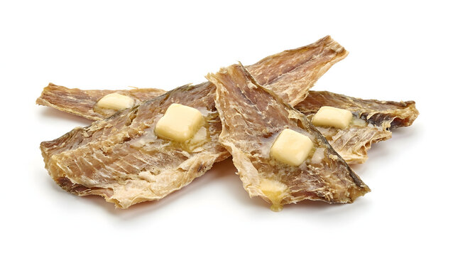 Pieces of traditional Icelandic wind-dried fish jerky served with salted butter, isolated on a white background