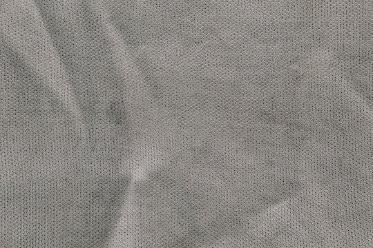 Seamless grey micro mesh fabric texture with soft shadows and weave.