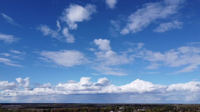 4K aerial drone view of vast blue sky with white fluffy clouds over a distant horizon, cinematic wide angle landscape, peaceful sunny day, high altitude perspective, clear weather background for comme