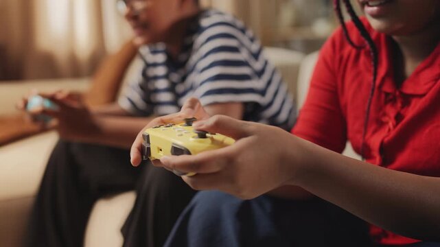 Girl competing with her brother in a video game, pressing gamepad buttons