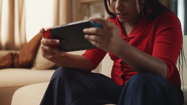 Relaxed Black girl playing on video game console, home entertainment concept