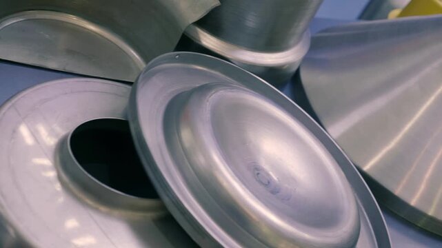 Shiny examples of stamped sheet metal parts are presented at the exhibition. Closeup. Shot in motion