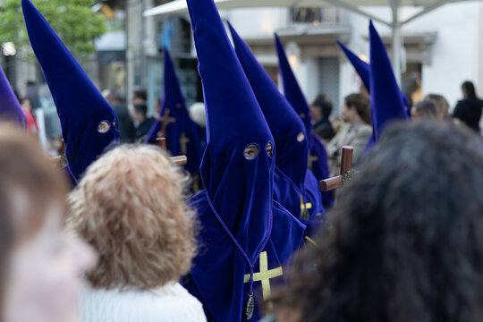 Penitents in blue velvet robes and pointed hoods (capirote) participating in a Holy Week procession, a traditional Spanish religious celebration in Avil&eacute;s, Asturias. 2026