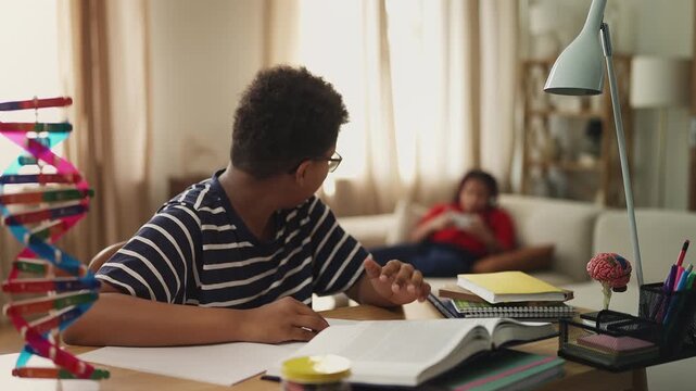 Tired boy trying to study while sister loudly plays video game on background