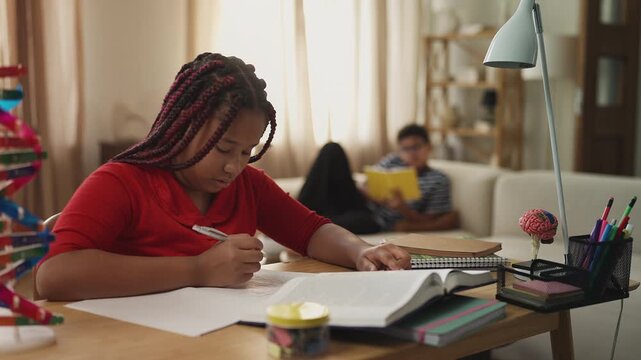 Two diligent African American siblings studying and reading separately at home