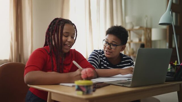 Positive children having online lesson on laptop, distance education concept