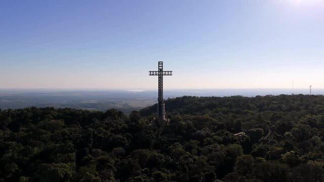 Tall Cross Towering Over Lush Forest Parque temático de la Cruz with R&iacute;o Paran&aacute; in the Distance on a Sunny Day, Santa Ana, Misiones, Argentina.