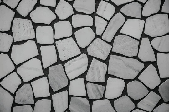 Abstract white and gray stone mosaic pattern with various shapes and sizes of rock pieces on a dark background.
