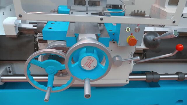 Lathe control levers and flywheels on the front panel for mechanical switching of equipment operating options. Closeup. Shot in motion