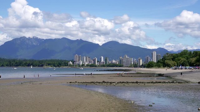 Kitsilano Beach Low Tide Summer 4K UHD. Kitsilano Beach on English Bay in the summer. In the background are the North Shore Mountains. Vancouver, British Columbia, Canada. 4K. UHD.
