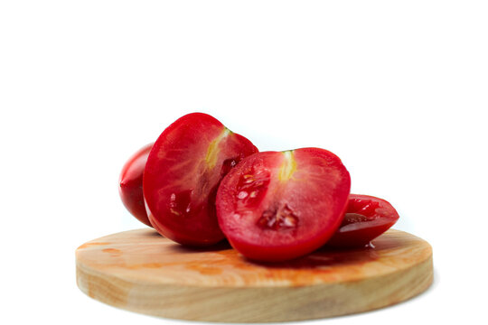 Halved tomatoes on wooden board isolated on white background