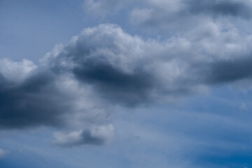 Obraz premium Dramatic dark storm clouds forming in blue sky before rain