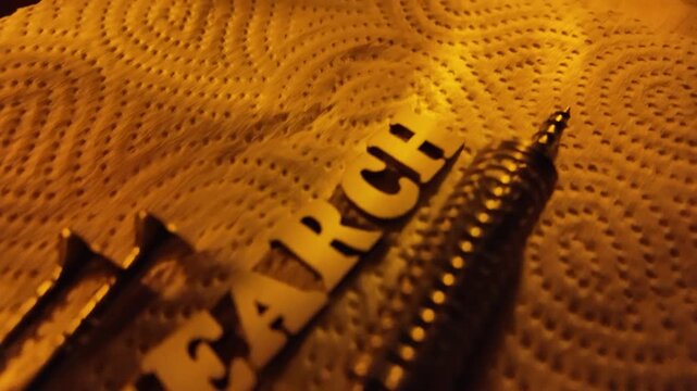 A coiled spring and screws are arranged near the word SEARCH on a textured surface.
