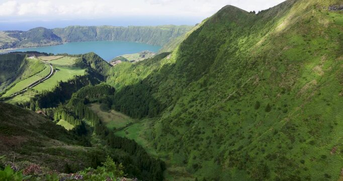 A beautiful view of a volcanic lake in a crater surrounded by mountains at Sete Cidades.