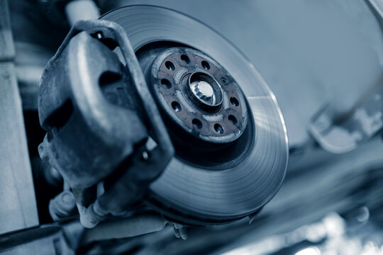 Detailed brake disc and caliper assembly on vehicle lift
