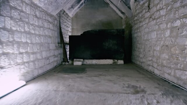 Bare limestone interior burial chamber inside pyramid of Teti at Saqqara necropolis, Egypt, narrow corbelled ceiling passage leading to dark empty sarcophagus room.