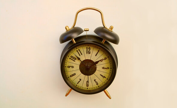 classic retro vintage aged black twin bell alarm clock with the hands pointing to 14 two 2 o'clock, isolated on clean white background symbolizing time deadlines Empty copy space for inscription