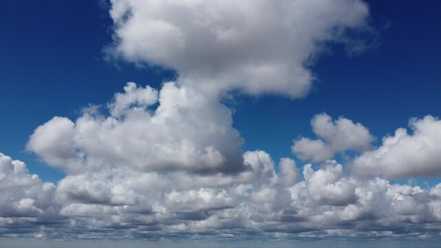 4K aerial drone view of a vast textured cloudscape under a bright blue sky, cinematic high altitude perspective, beautiful fluffy white clouds background for commercial and nature video, peaceful sunn