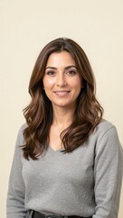 Fototapeta premium Woman smiling in neutral studio portrait with beige background