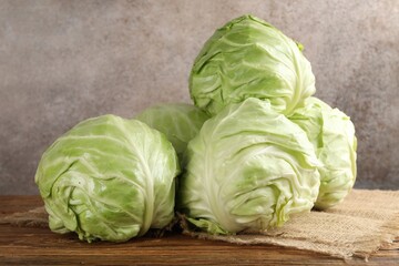 Fototapeta premium Fresh whole cabbages on wooden table, closeup