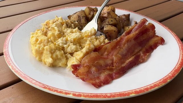 Eating Scrambled Eggs, Bacon and Potatoes
