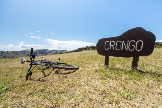 Mountain bike beside Orongo welcome sign in Easter Island volcanic landscape