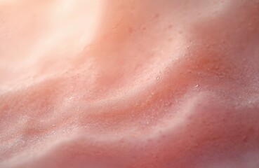 Fototapeta premium Macro abstract shot of pinkish human skin texture with light reflecting off tiny water droplets. Natural seamless surface reveals healthy complexion, detail.