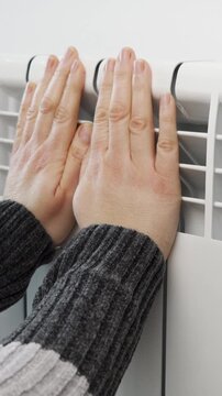 woman hand&acute;s heating touching central radiator thermostat save energy power cold temperature closeup. Domestic warming cost price increase control household expenses reduce money economy